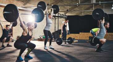 people working out and holding up dumbbells