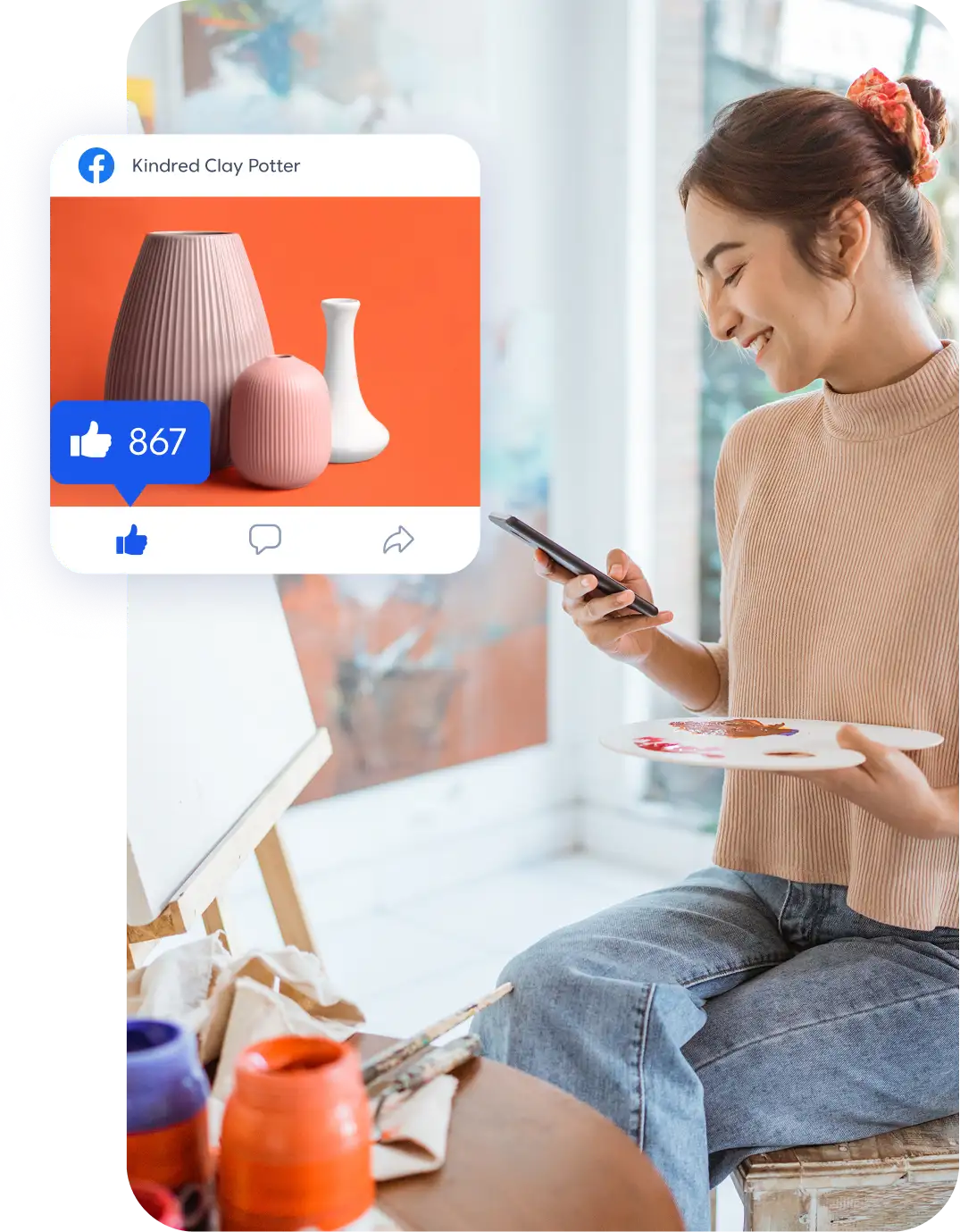 Artist checking social media post of pink ceramic vases while holding paint palette and smartphone.