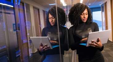 woman holding her laptop at a technology company