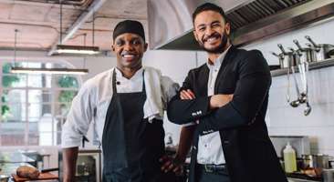 chef standing next to restaurant manager in a kitchen
