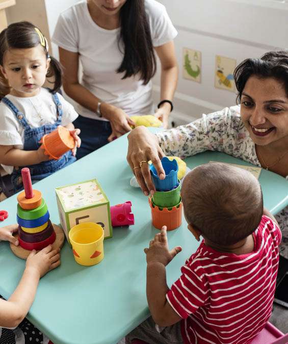 Teacher playing with children in a classroom