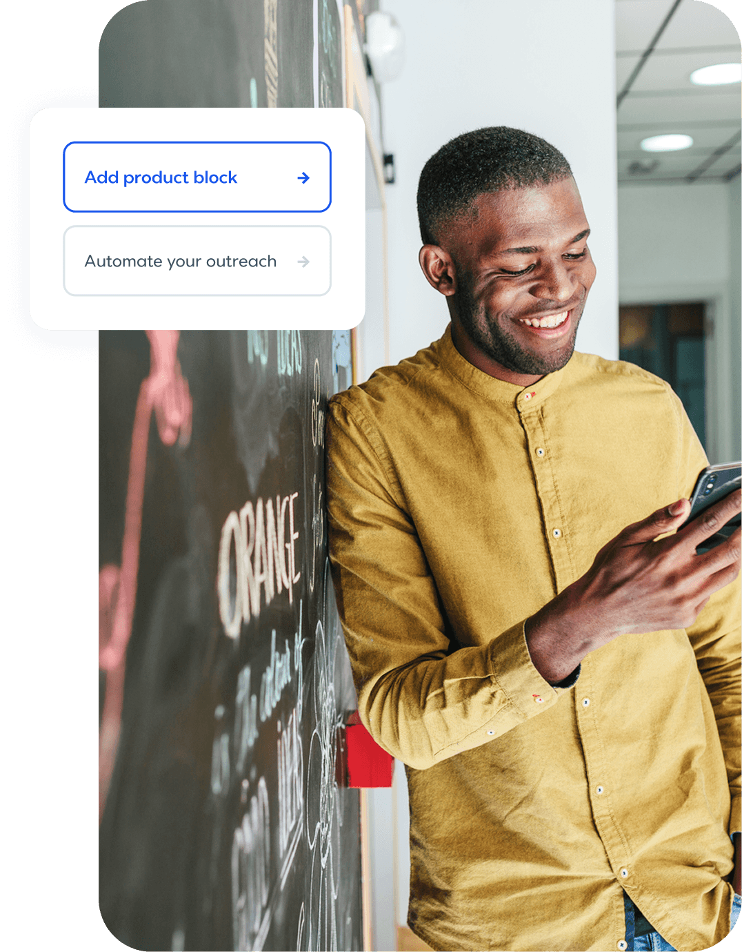 Smiling man in yellow shirt looking at phone next to chalkboard with product interface overlay showing feature options.
