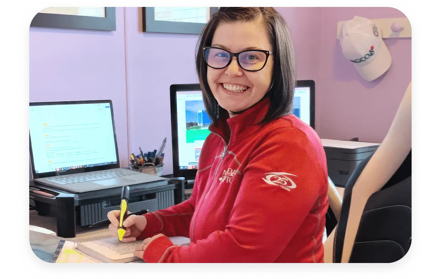 A woman sitting at a desk smiling at the camera