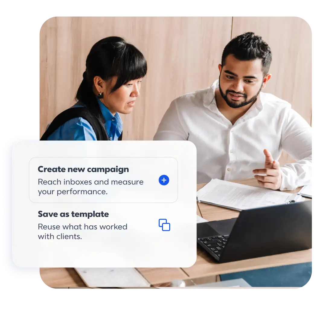 White UI card with two options: "Create new campaign" and "Save as template" with descriptions. In the background, a man and a woman are seated at a wooden table looking toward a laptop and physical documents.