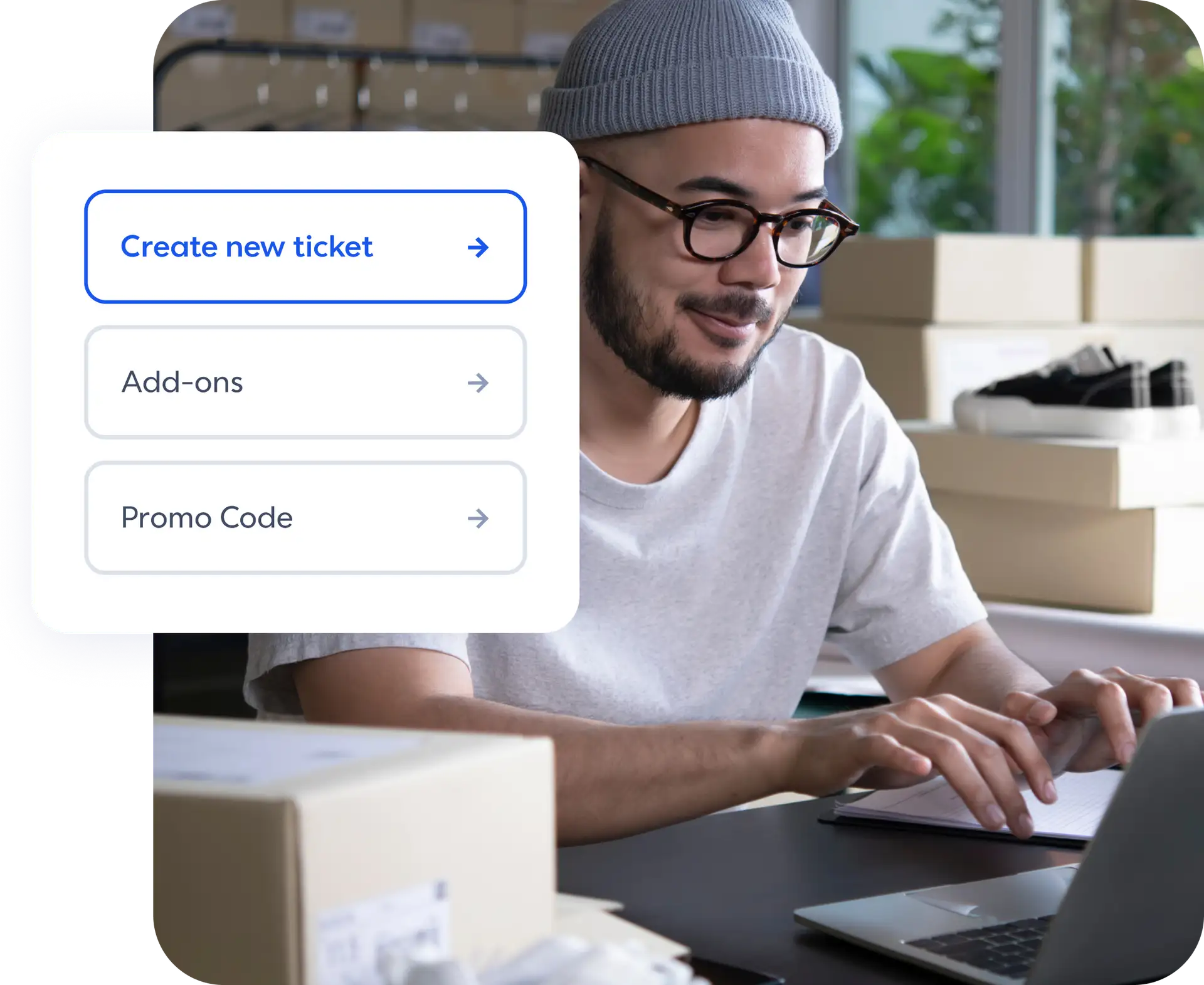 A man sitting at a desk typing on a laptop with 3 actions: create new ticket, add-ons, and promo code.