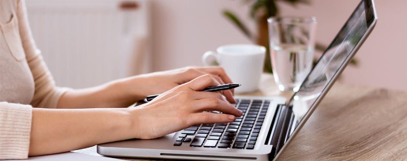 Hands typing on a laptop