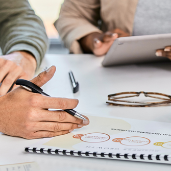 Business professionals around a table hands and business plans
