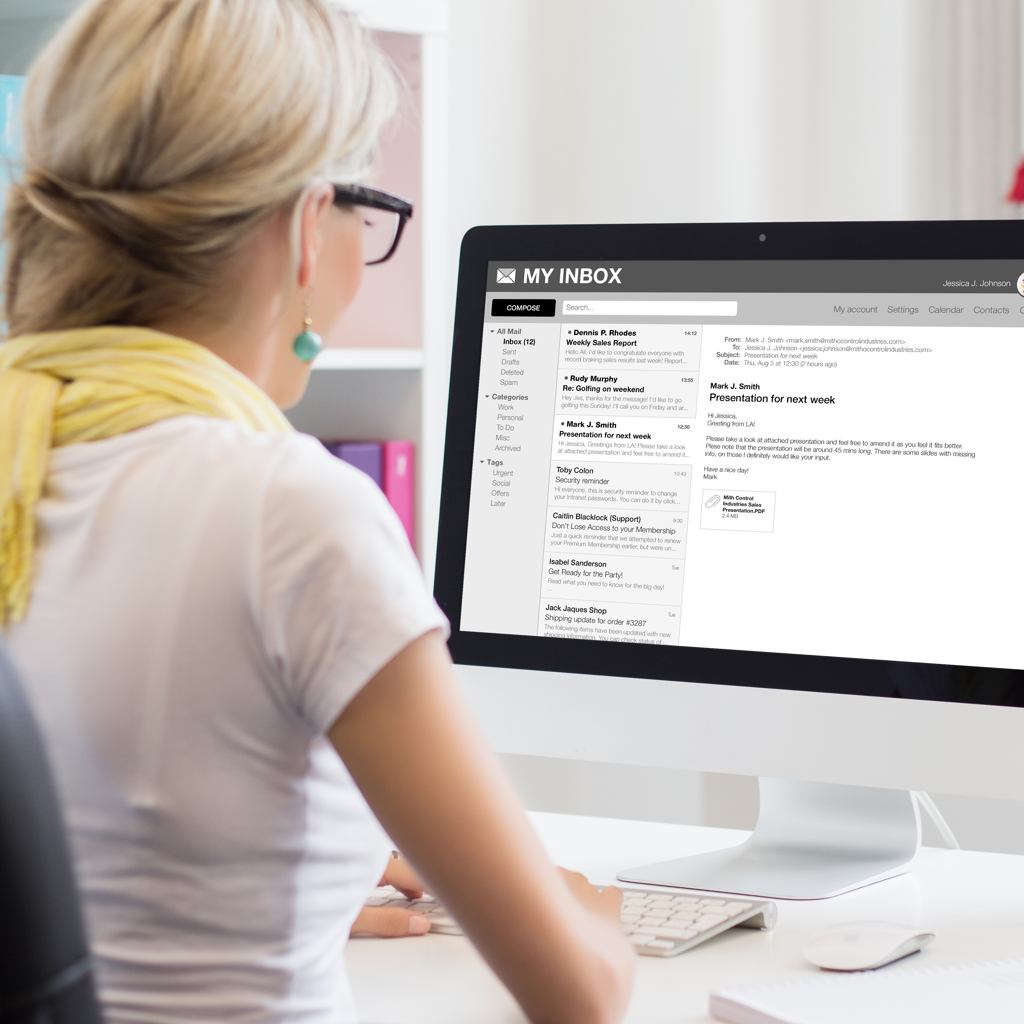 A person sits in front of a computer monitor displaying an email inbox.