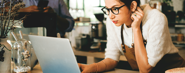 This is an image of a woman looking at her laptop