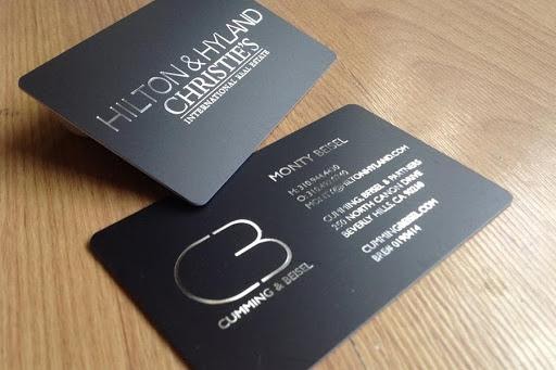 real estate business card with silver text on a black card