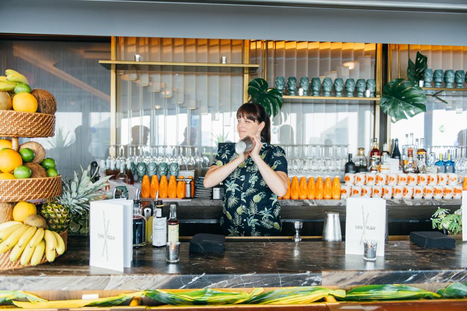 Rainbow Room NYC event marketing example featuring a pop-up tiki bar and a woman preparing drinks