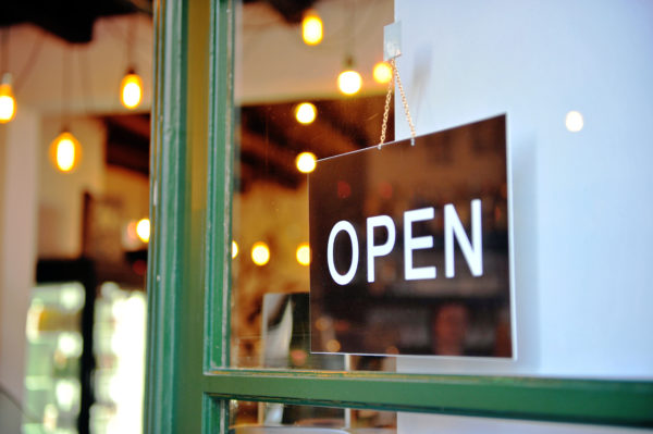 keep your doors open regardless of retail sales seasonality -- retail open sign on glass door framed in green