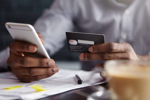 man starting a monthly giving plan by entering credit card information on a cell phone