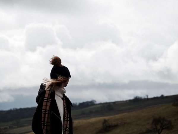 Woman bundled in hat and scarf looking off to the distance