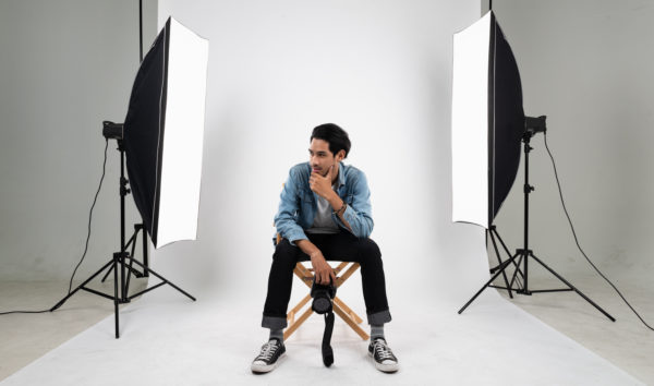 photographer sitting between two large lighting diffusers