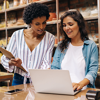This is an image of two women looking at a laptop screen