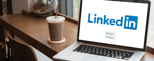 A laptop screen displays the LinkedIn logo.