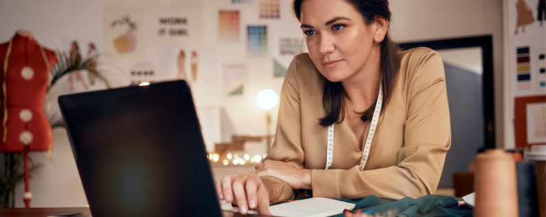 Email nurturing blog header Boutique owner working on laptop