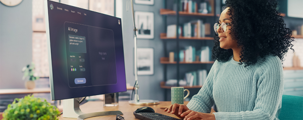 A woman sits at her desk and types a query into an AI search engine on her desktop computer.