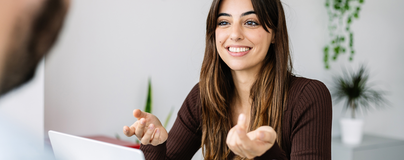Ecommerce email marketing blog header Female marketer at desk explaining ecommerce email marketing to a male colleague