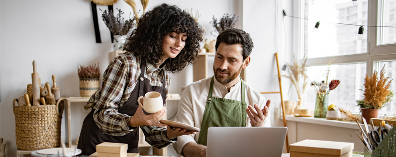 Email broadcasting blog header two shop owners working on email marketing