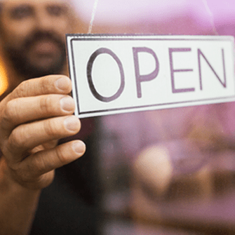 Business owner turning open sign