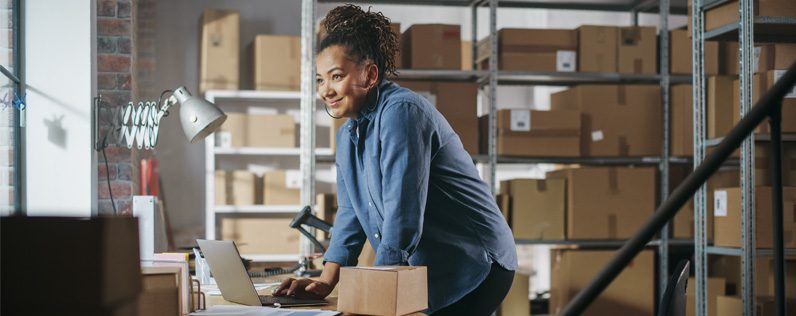 Canadian Tariff Header A black woman in a small business stockroom fulfilling an order.