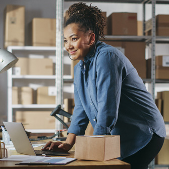 A thumbnail version of a black woman fulfilling an order in front of a laptop.
