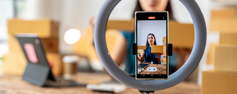Woman filming content for social media with ring light