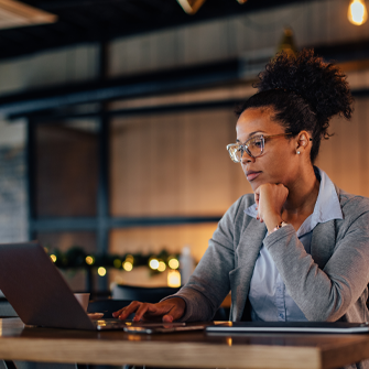 A Black woman business owner works on a computer