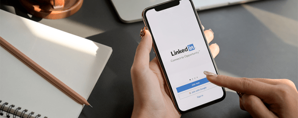 A person uses their smartphone to log into the LinkedIn app.