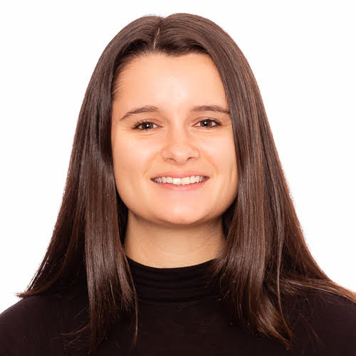 Professional headshot of Hannah Vona, smiling and wearing a black top, on a white background.