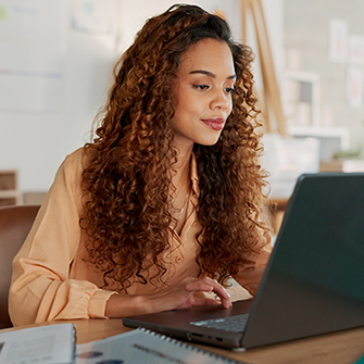 A woman types on a laptop.