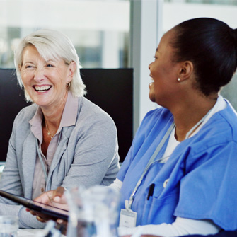 A healthcare executive and provider sit side by side