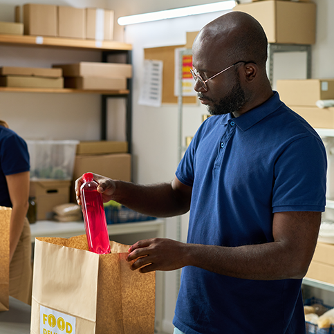 Volunteers fill bags at a food bank.