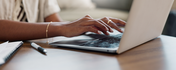 This image captures a top-down view of someone typing on a laptop.
