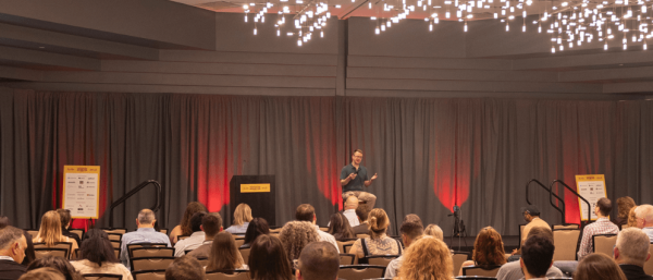 Long distance shot of email marketing researcher Chad S. White speaking at an audience, probably during a conference.