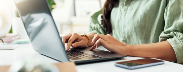 A woman with dark hair on a laptop