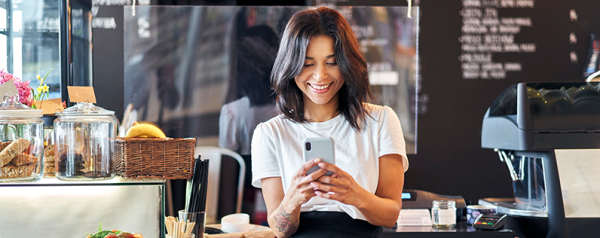 A woman smiling while looking at her cell phone