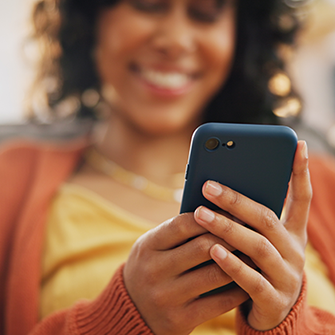 A person looks down at a smartphone in their hand.