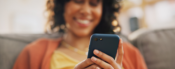 A person looks down at a smartphone in their hand.