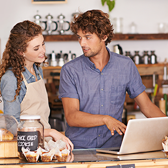 A man with a laptop explaining something to a woman