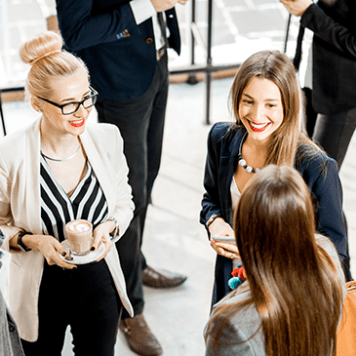Three women discussing during an event.