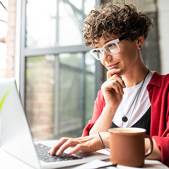 This is an image of a woman sitting with her laptop in front of her.