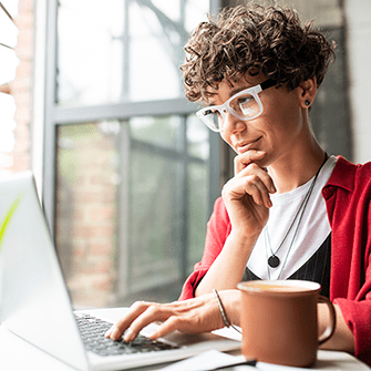 This is an image of a woman sitting with her laptop in front of her.