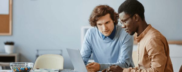 Two people working together in front of a laptop