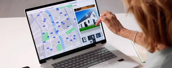 A woman browsing real estate listings on a laptop.
