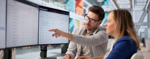 Two people reviewing data on screens