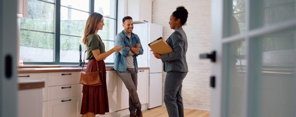 Real estate agent standing with a couple in a house
