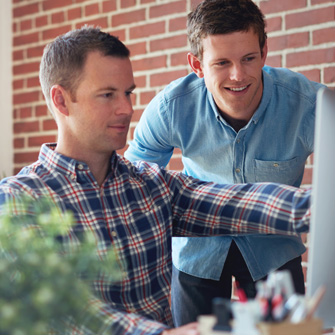 Two men gathered around a computer display.